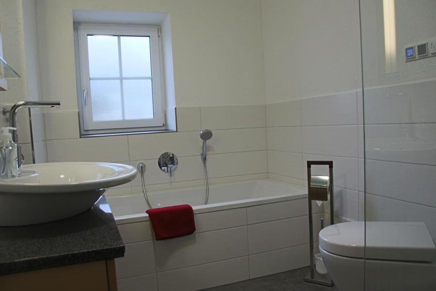 Bathroom with tub and rain shower